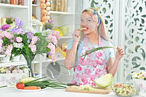 Young woman cooking healthy food in kitchen