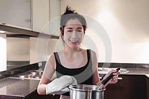 Young woman cooking in home kitchen  with smiling face