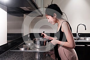 Young woman cooking in home kitchen  with smiling face