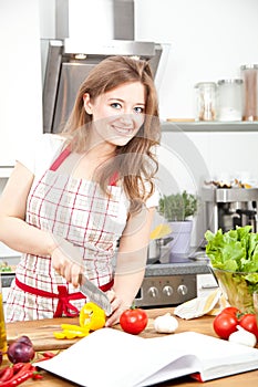 Young Woman Cooking in the kitchen. Healthy Food - Vegetable Sal