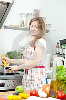 Young Woman Cooking in the kitchen. Healthy Food - Vegetable Sal