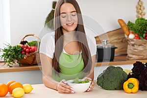 Young woman cooking in kitchen. Householding, tasty food and vegetarian in lifestyle concepts