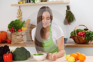 Young woman cooking in kitchen. Householding, tasty food and vegetarian in lifestyle concepts