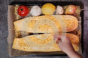 Young woman cooking in a kitchen. Housewife preparing vegetables for cooking. Girl put fresh fried meat into yellow zucchini.