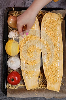 Young woman cooking in a kitchen. Housewife preparing vegetables for cooking. Girl put fresh fried meat into yellow zucchini.