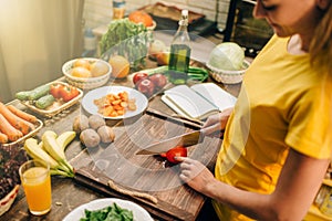 Young woman cooking on recipes, healthy bio food