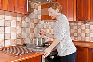 Young woman cooks on the stove