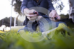 Young woman cordoning her running shoes off for a run sesion outdoors in the park photo