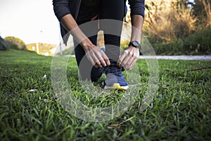 Young woman cordoning her running shoes off for a run sesion outdoors in the park photo