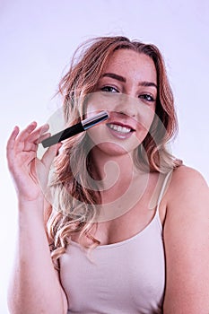 Young woman with cosmetic pencil