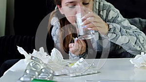 Young woman coughing and taking a pill