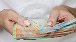 Young woman counting various Euro bills in hands, closeup view on banknotes. Business crisis concept.