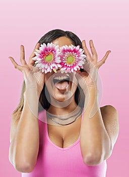 Young woman covering eyes with flowers