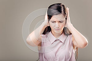 Young woman covering her ears. Hear no evil concept