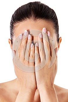 Young woman covering her face with her hands. photo