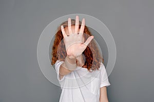 Young woman covering her face with palm