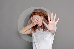 Young woman covering her face with palm
