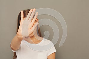 Young woman covering her face with palm