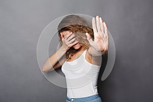 Young woman covering her face with palm