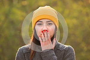 Young woman covering her mouth with her hand