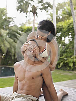 Young Woman Covering Man's Eyes