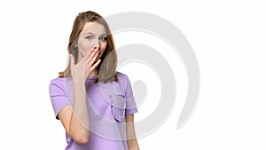 Young woman covering mouth with hand, looking serious, promises to keep secret. Place for your text