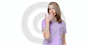 Young woman covering mouth with hand, looking serious, promises to keep secret. Place for your text