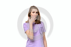 Young woman covering mouth with hand, looking serious, promises to keep secret. . Studio shot, white background