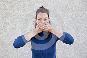 Mujer joven cubierta boca manos 