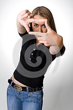 Young woman creates a frame with her hands