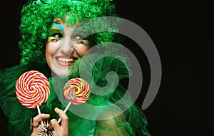 Young woman with creative visage with lollipops. Party and carnival. Bright wig.