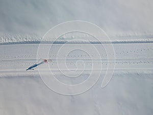 Young woman cross-country skiing on a winter day motion blurred image - aerial image