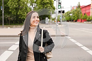 Young woman crossing street. Traffic rules