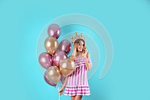 Young woman with crown and air balloons