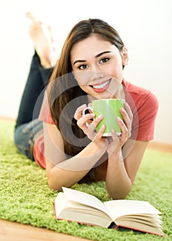 Young woman with cup and book
