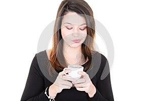Young woman with cup of coffee looks down mug