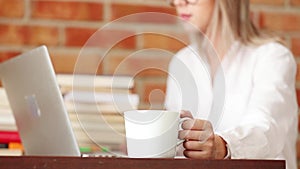 Young woman with cup and laptop computer