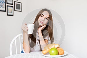 Young woman with cup of tea having breakfast in the morning. Healthy Eating, Breakfast, Women.