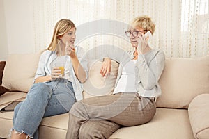 Young woman is curious and anticipating good news from her mother who is talking on the phone