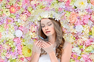 young woman with curly hair in floral wreath with butterfly photo
