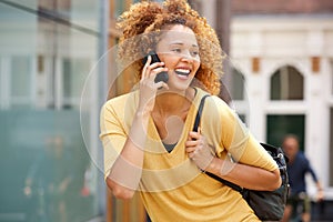 Young woman with curly hair talking on mobile phone in the city