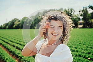 Young woman with curly hair in a white dress with a bouquet of flowers