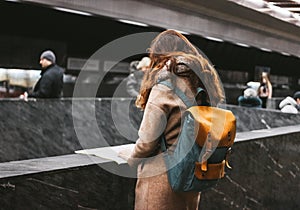 Young woman curly red head girl traveller with backpack and map in subway