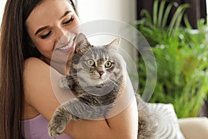 Young woman with cute cat at home. Pet and owner