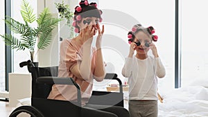 Young woman and cute daughter doing hair perm and applying patches.