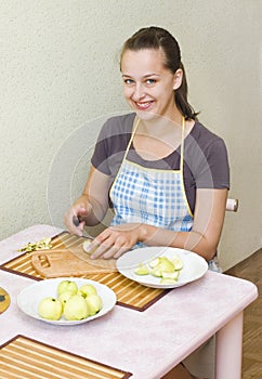 A young woman cuts the apples