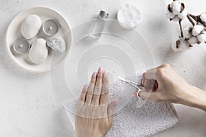 Young woman cutting nails with manicure scissors. hygiene concept.