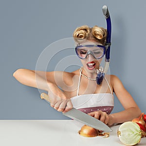 Young woman cutting onion in diving mask