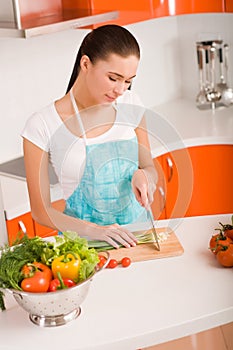 Young woman cutting vegetables in a kitchen