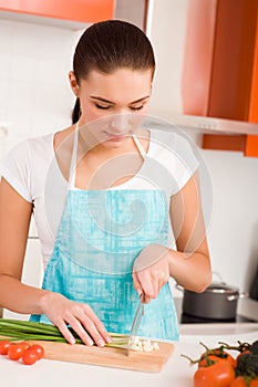 Young woman cutting vegetables in a kitchen